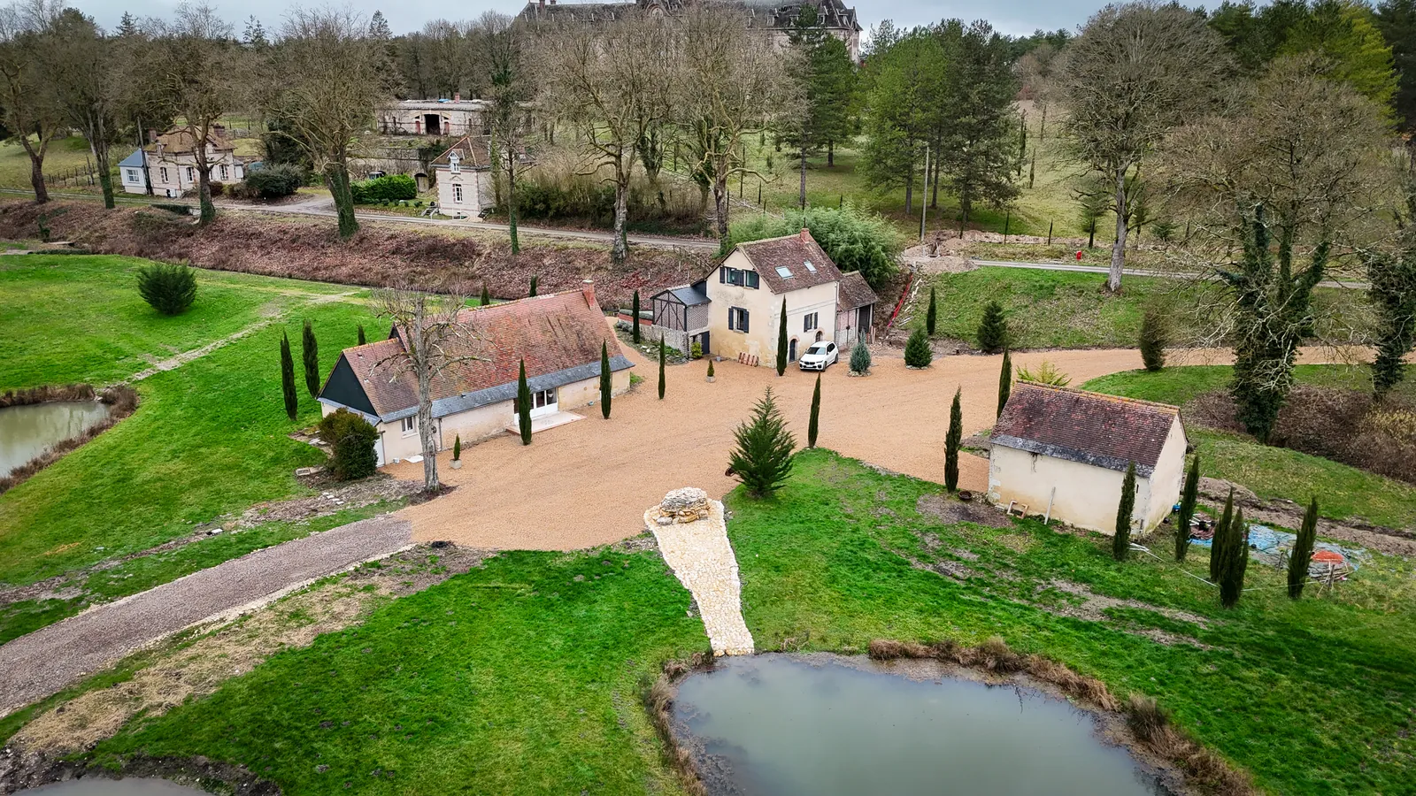 Vue aérienne des bâtiments, de la cour et des mares du domaine à La Haute Barde
