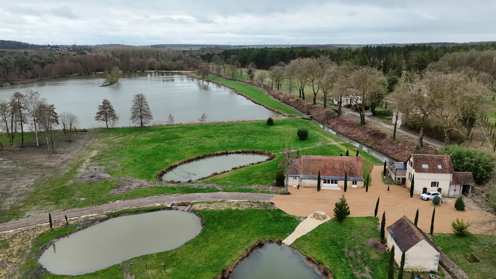 Vue aérienne des bâtiments, de la cour et des mares du domaine à La Haute Barde
